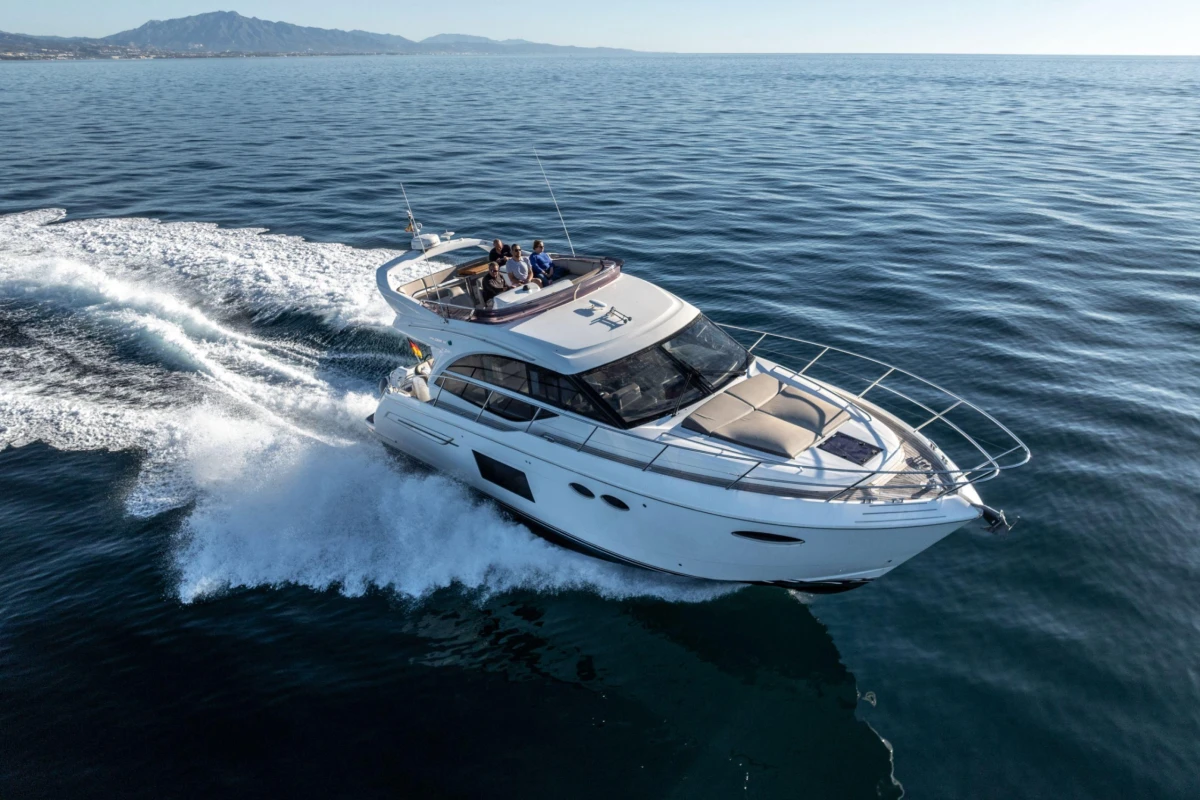 Luxurious 2017 Princess 49 yacht cruising on open sea, creating a dynamic wake.
