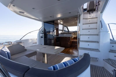 Luxurious 2017 Princess 49 yacht interior with seating, table, and stairs.