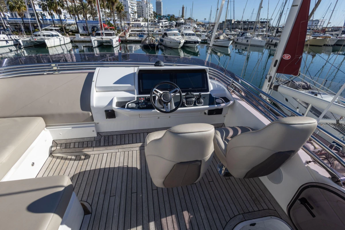 Luxurious 2017 Princess 49 yacht helm with modern controls, docked in a marina.