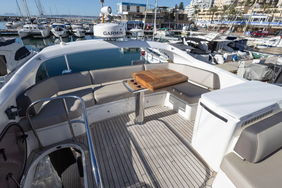 Luxurious 2017 Princess 49 yacht deck with seating and table in marina.