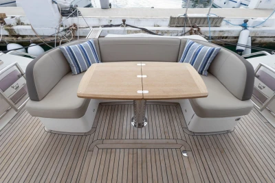 Luxurious seating area on 2017 Princess 49 yacht with wooden table and striped cushions.