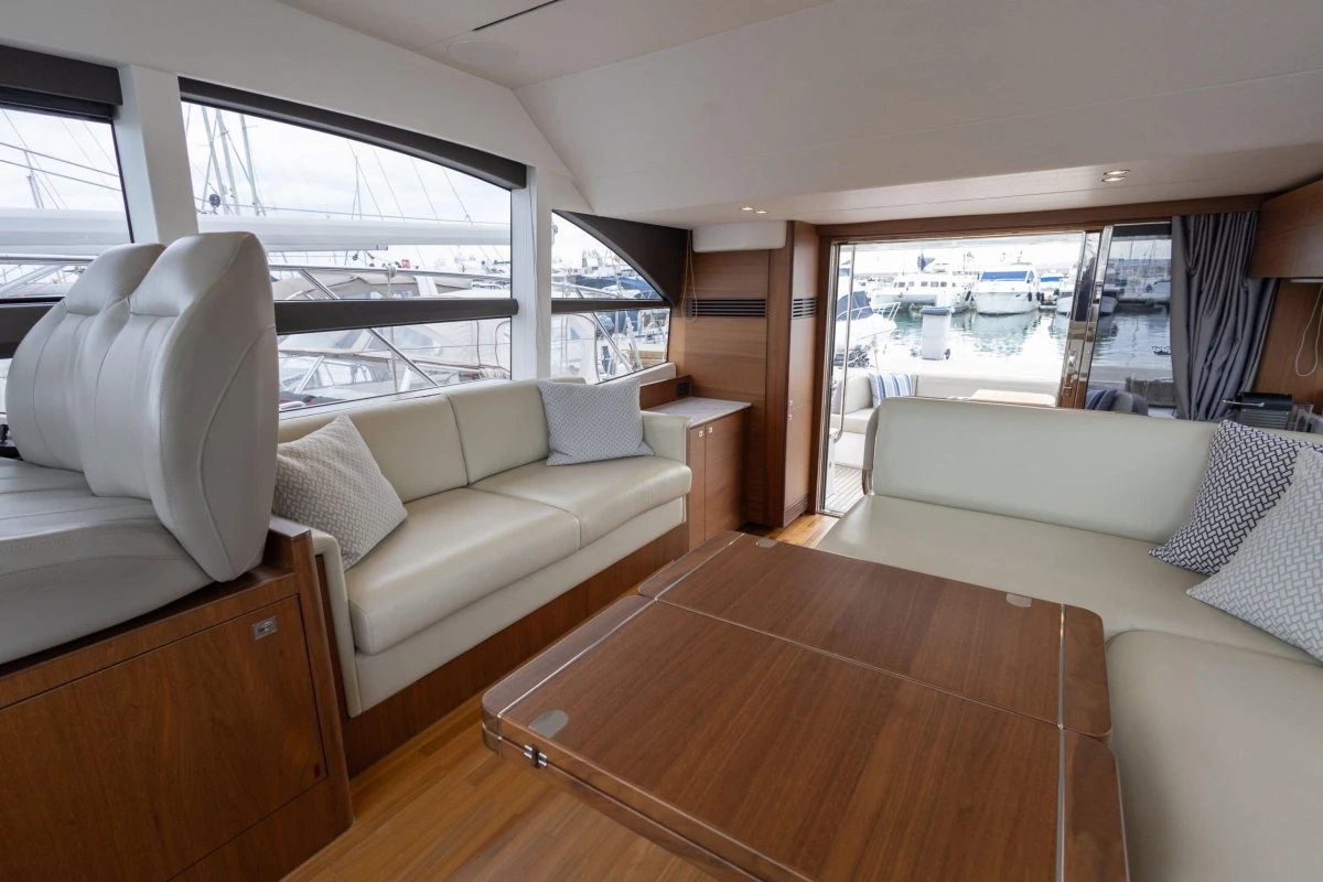Luxurious interior of 2017 Princess 49 yacht with elegant seating and marina view.