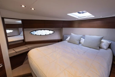Luxurious bedroom interior of 2017 Princess 49 yacht with elegant bedding and wood accents.
