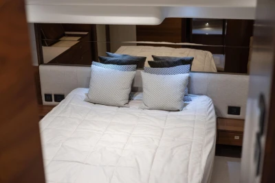 Luxurious bedroom interior of 2017 Princess 49 yacht with elegant bedding and cushions.
