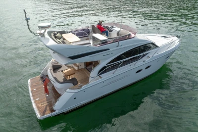 Luxury 2016 Princess 43 yacht cruising on calm waters, featuring spacious deck and modern design.