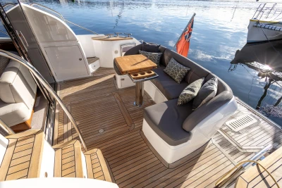 Luxurious 2016 Princess 43 yacht deck with elegant seating and wooden table.