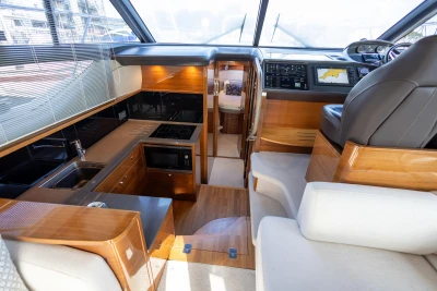Luxurious interior of 2016 Princess 43 yacht with modern kitchen and navigation area.