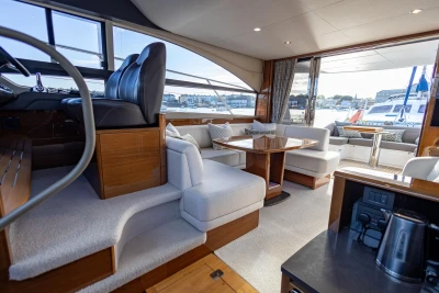 Luxurious interior of a 2016 Princess 43 yacht with elegant seating and helm station.