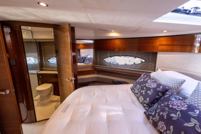 Luxurious cabin interior of 2016 Princess 43 yacht with elegant bedding and ensuite bathroom.