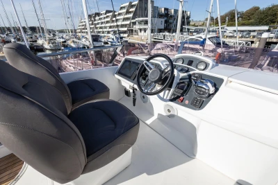 Helm of 2016 Princess 43 yacht with dual seats and modern controls in marina setting.