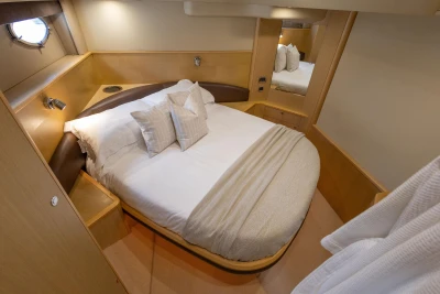Luxurious cabin interior of 2009 Princess V58 yacht with cozy bed and elegant decor.