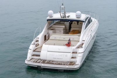 2009 Princess V58 yacht on water, rear view with open deck and flag.