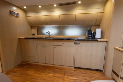 Luxurious 2009 Princess V58 yacht kitchen with modern wood cabinetry and sleek countertops.