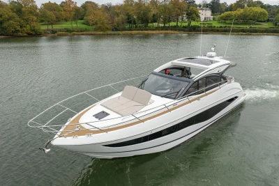 2022 Princess V50 yacht cruising on a serene river with lush greenery.