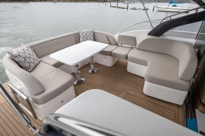 Luxurious 2022 Princess V50 yacht deck with elegant seating and table, overlooking serene waters.