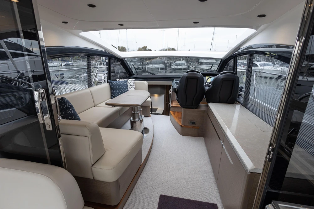 Luxurious interior of 2022 Princess V50 yacht with seating and helm station.