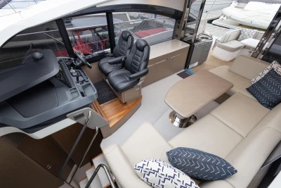 Luxurious interior of 2022 Princess V50 yacht with plush seating and modern helm.