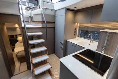 Luxurious interior of 2022 Princess V50 yacht featuring modern kitchen and staircase.