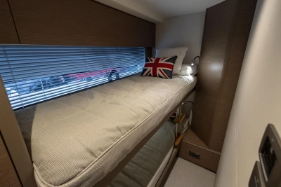 Cozy cabin interior of 2022 Princess V50 yacht with bunk beds and Union Jack pillow.