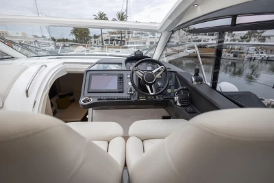 Interior view of 2016 Princess V39 yacht cockpit with modern controls and steering wheel.