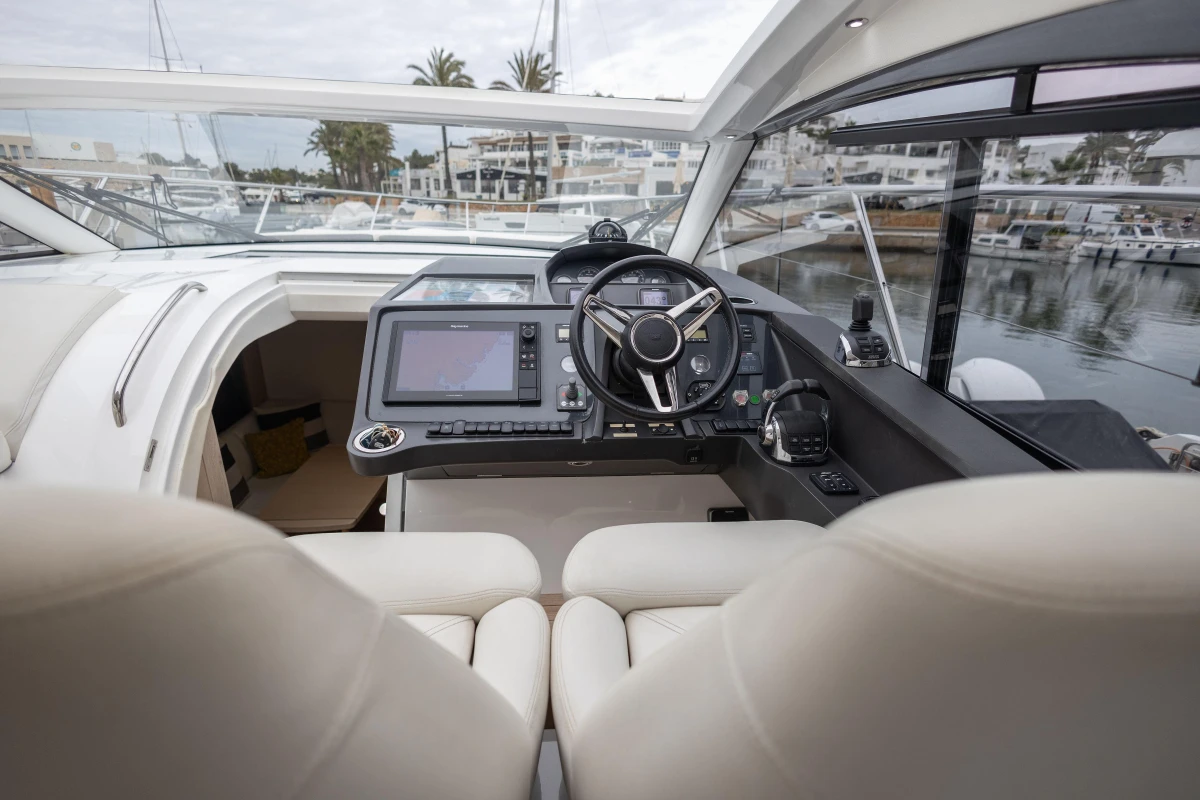 Interior view of 2016 Princess V39 yacht cockpit with modern controls and steering wheel.