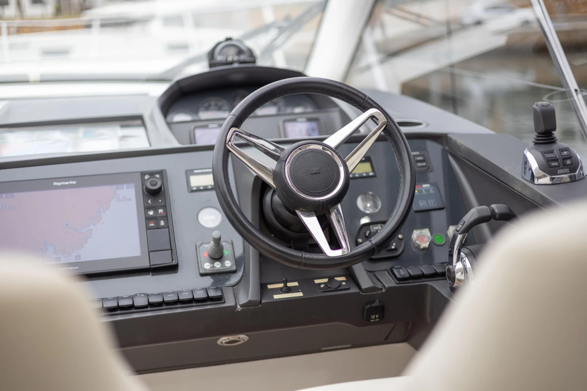 Steering wheel and dashboard of 2016 Princess V39 yacht, featuring navigation controls and displays.