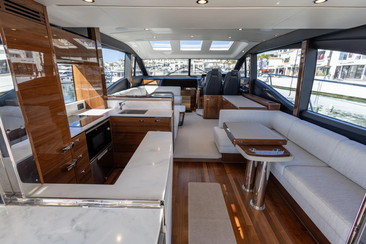 Luxurious interior of 2023 Princess S62 yacht with modern kitchen and seating area.