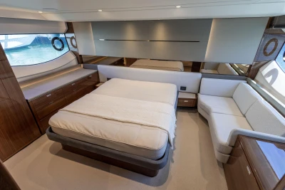 Luxurious 2023 Princess S62 yacht bedroom with elegant furnishings and large windows.