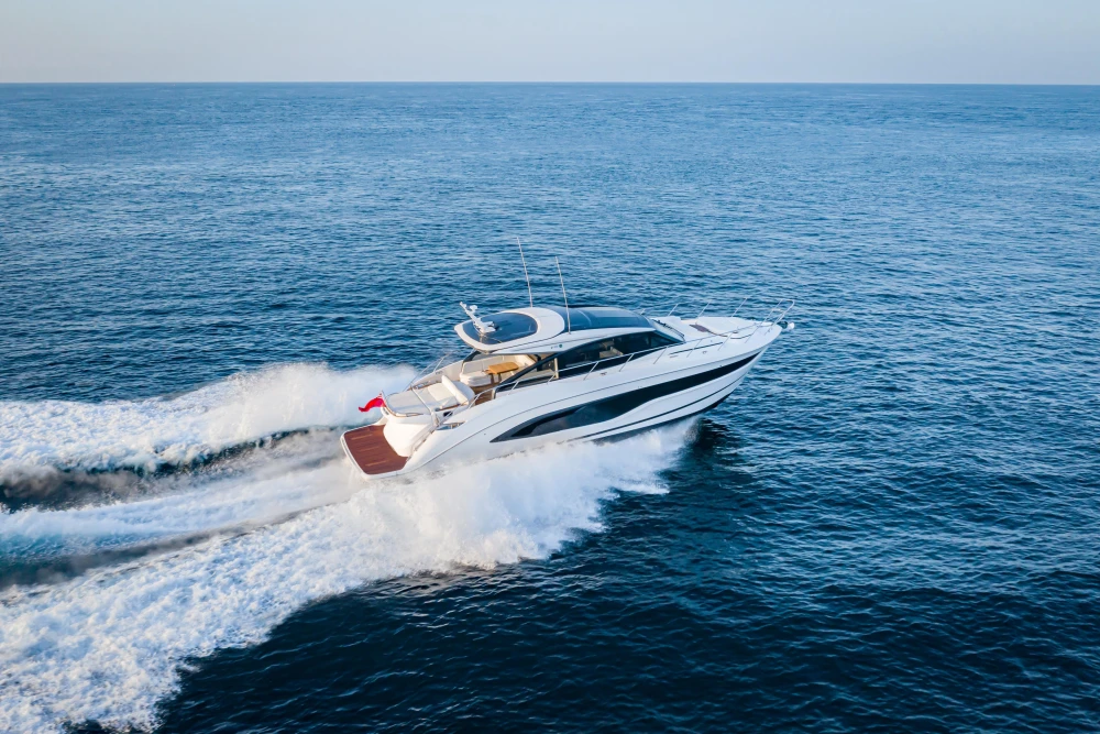 Luxurious 2025 Princess V55 yacht cruising on open sea, showcasing sleek design and performance.