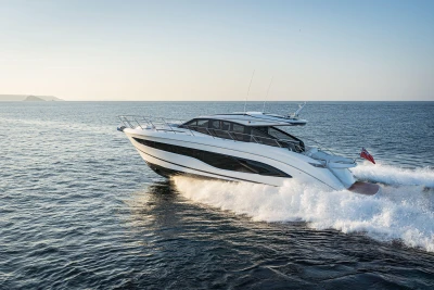 2025 Princess V55 yacht cruising on open sea at sunset.