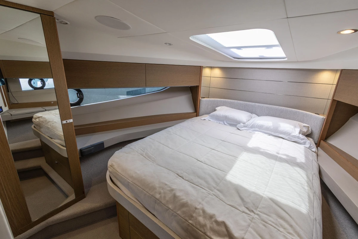 Luxurious bedroom interior of 2019 Princess V40 yacht with modern design and skylight.