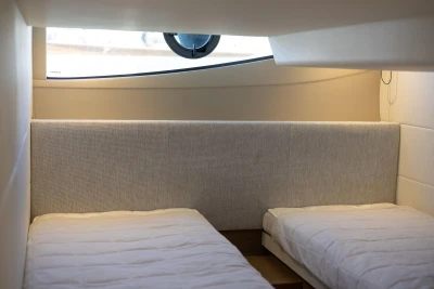 Twin beds in a 2019 Princess V40 yacht cabin, featuring a modern interior design.