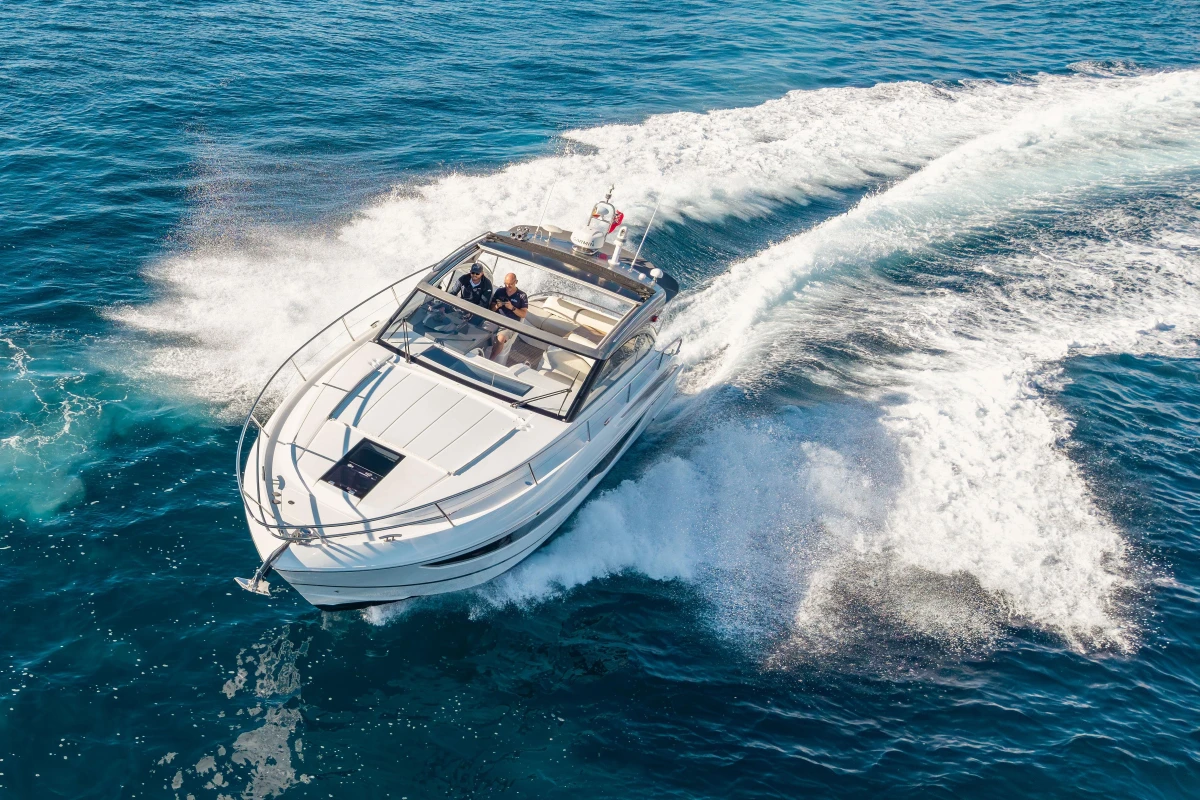 2019 Princess V40 yacht cruising on open blue sea, creating white waves.