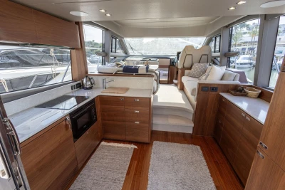 Luxurious interior of 2024 Princess F50 yacht with modern kitchen and seating area.