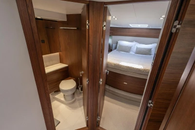 Luxurious 2024 Princess F50 yacht interior with bedroom and bathroom, featuring elegant wood finishes.