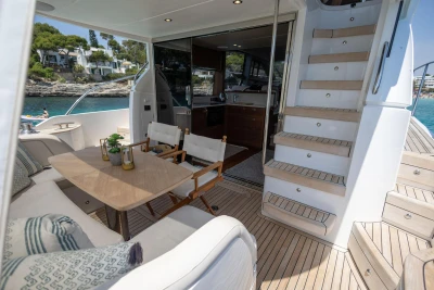 Luxurious 2024 Princess F50 yacht interior with elegant seating and wooden staircase.