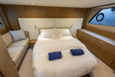Luxurious bedroom interior of 2017 Princess V48 Open yacht with cozy bed and elegant decor.