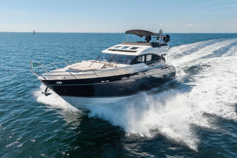 Luxurious 2014 Princess S72 yacht cruising on open sea under clear blue sky.