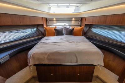 Luxurious cabin interior of 2014 Princess S72 yacht with elegant wood finish and cozy bedding.