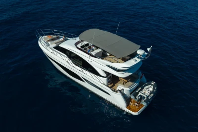 2023 Princess F55 yacht cruising on open blue sea, aerial view.