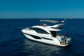 2023 Princess F55 yacht cruising on open blue sea under clear sky.