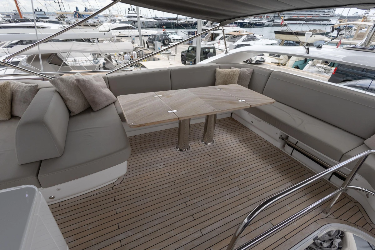 Luxurious 2023 Princess F55 yacht deck with elegant seating and wooden table.