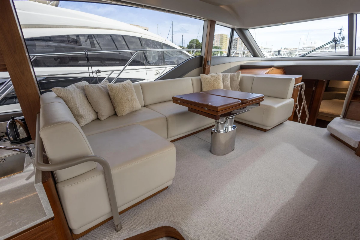 Luxurious interior of 2023 Princess F55 yacht with elegant seating and wooden table.