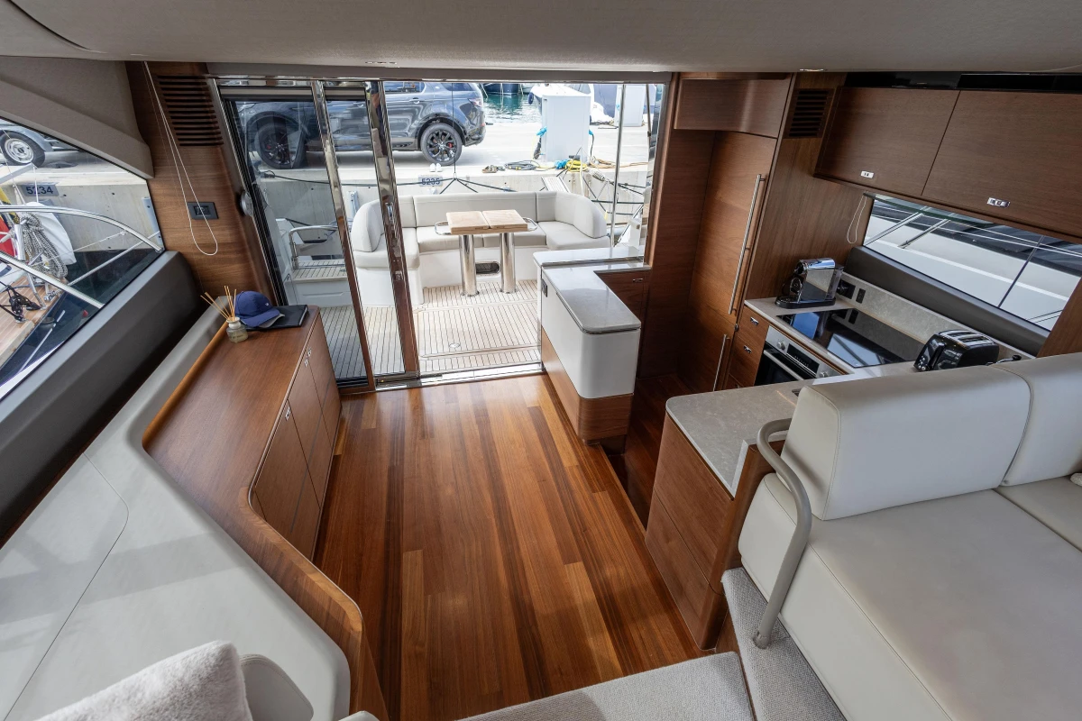 Luxurious interior of 2023 Princess F55 yacht with modern kitchen and seating area.