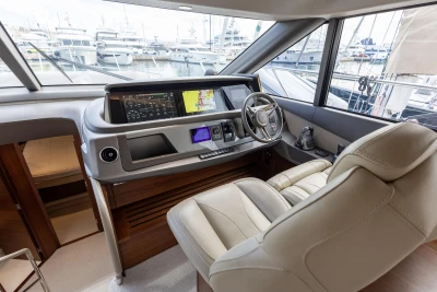 Luxurious 2023 Princess F55 yacht helm with modern navigation systems and plush seating.