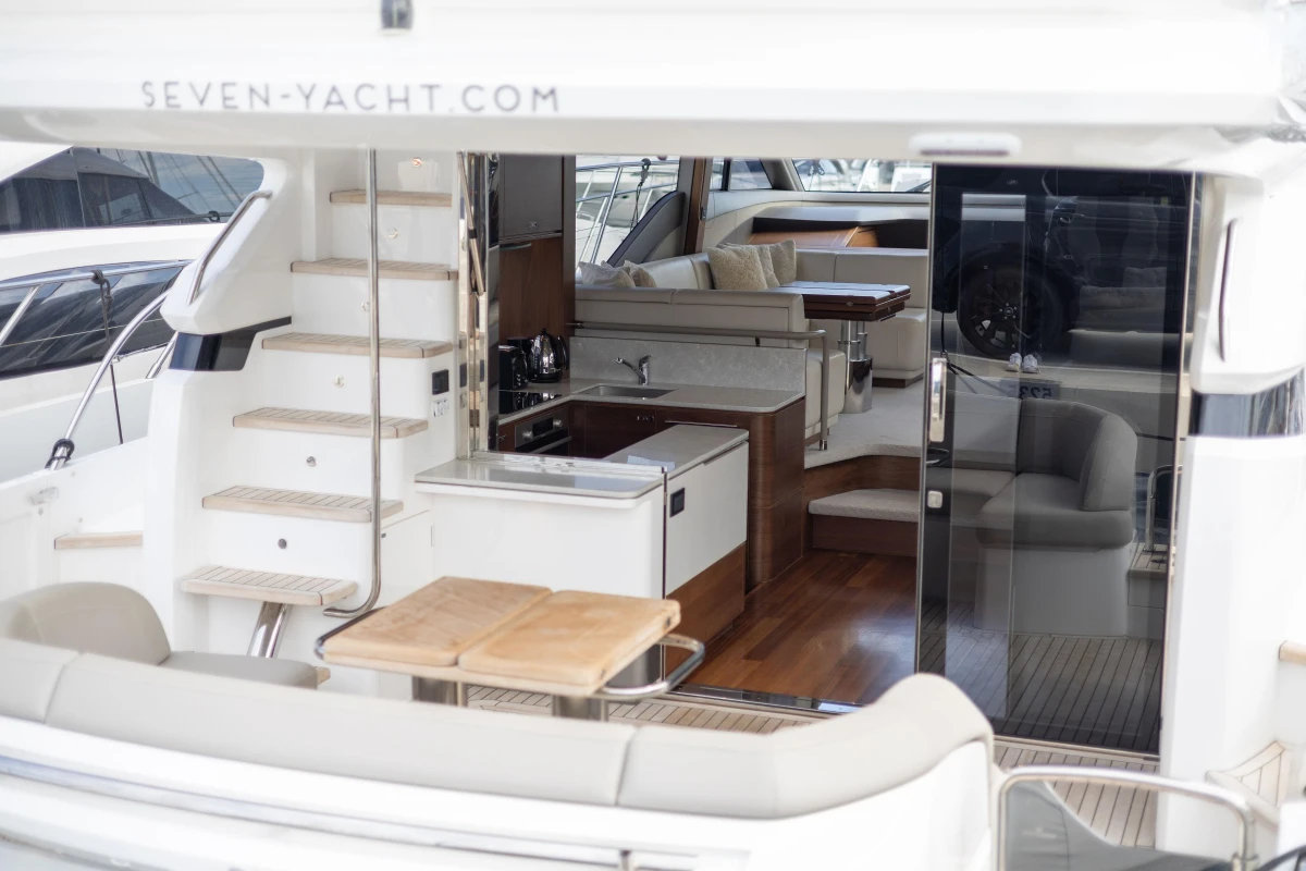 Luxurious 2023 Princess F55 yacht interior with modern kitchen and seating area.