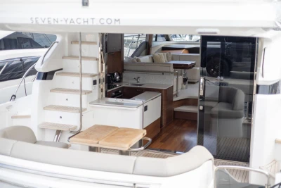 Luxurious 2023 Princess F55 yacht interior with modern kitchen and seating area.