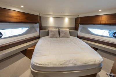 Luxurious bedroom interior of 2023 Princess F55 yacht with elegant wood accents.
