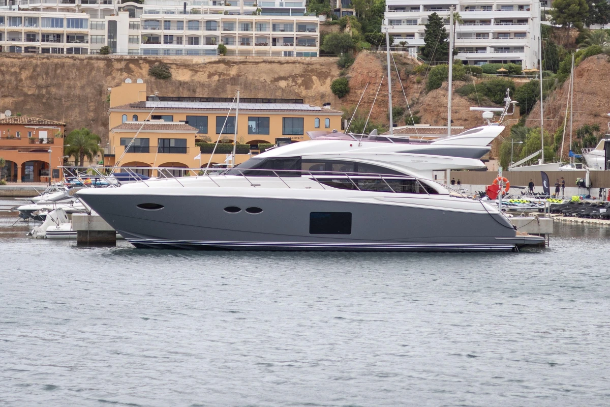 Luxury Princess 56 yacht docked in marina, 2014 model, with modern architecture in background.