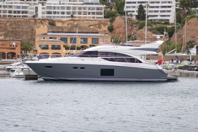Luxury Princess 56 yacht docked in marina, 2014 model, with modern architecture in background.